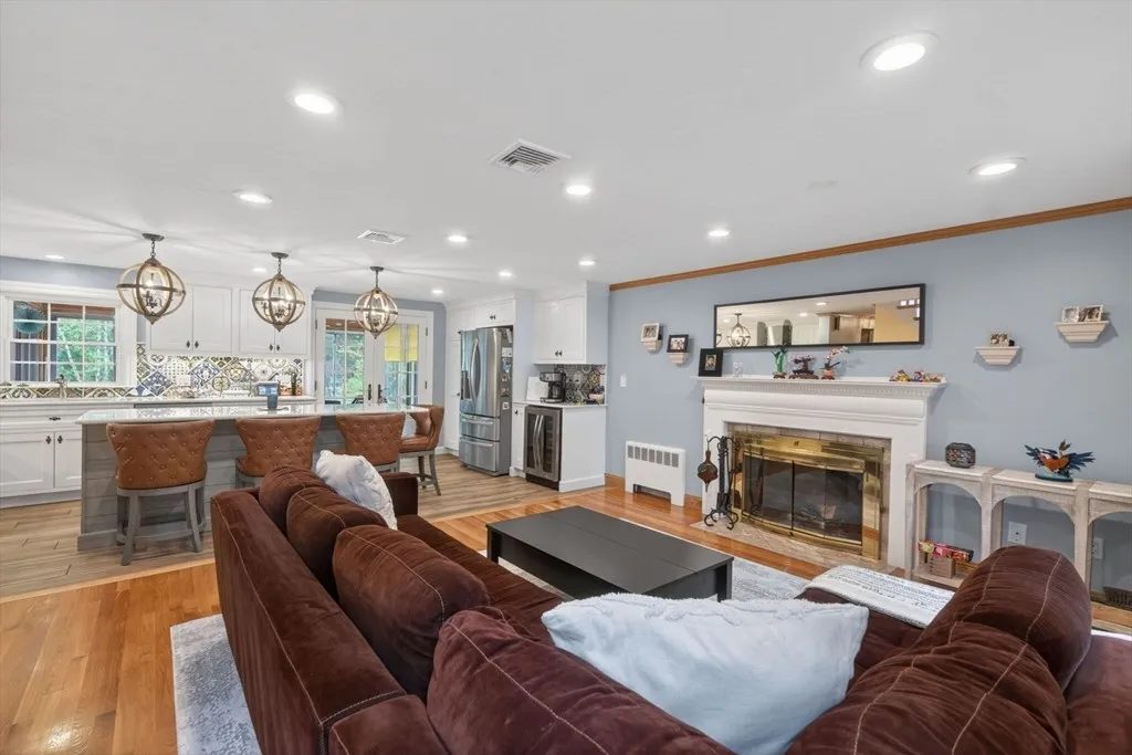 The fireplaced living room at 8 Hawthorne St with a classic mantel, tall windows, and warm hardwood floors