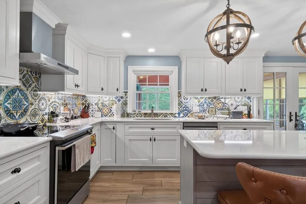 The renovated kitchen at 8 Hawthorne St with a large island, custom cabinetry, and a wood-beamed ceiling