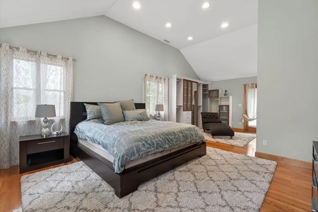 The primary suite at 8 Hawthorne St with a vaulted ceiling and large windows filling the room with light