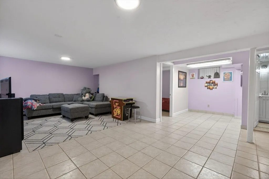 The finished lower level at 8 Hawthorne St, a bright flexible family room with a full bath and exterior access